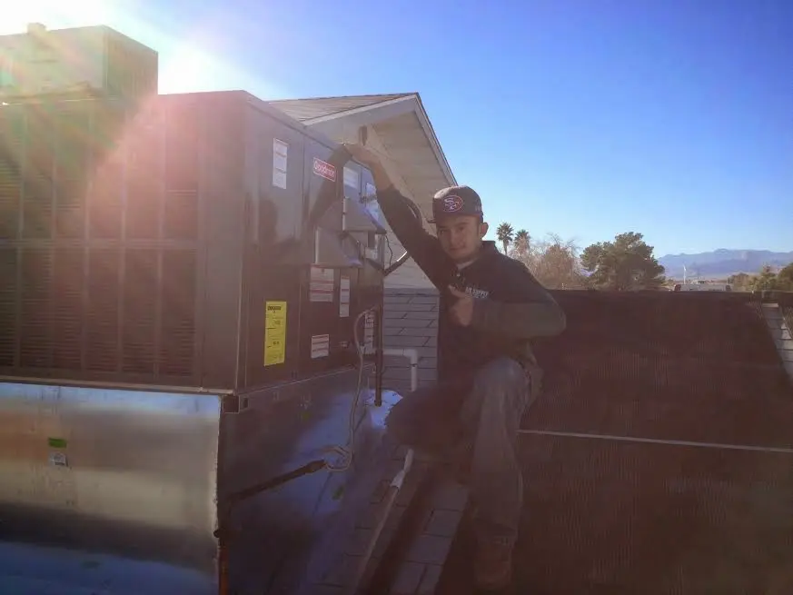 HVAC technician performing AC Tune-Up on a rooftop unit in Dunedin